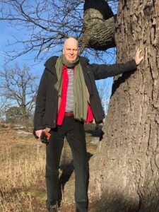 Anders Fagerlund står vid en ek 2021. 
Anders Fagerlund standing close by an oak.
